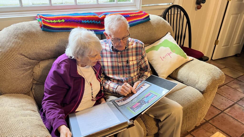 Jerry looking through a scrapbook with his friend. 